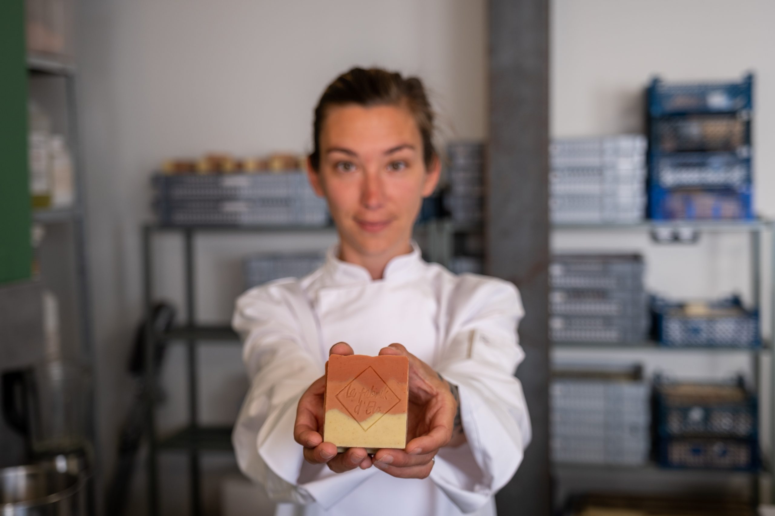 Photo d'Éloïse, créatrice de la marque La Fabrik d'Elo. boutique et Savonnière, elle tient dans ses mains un savon solide artisanal, fabriqué par ses soins.