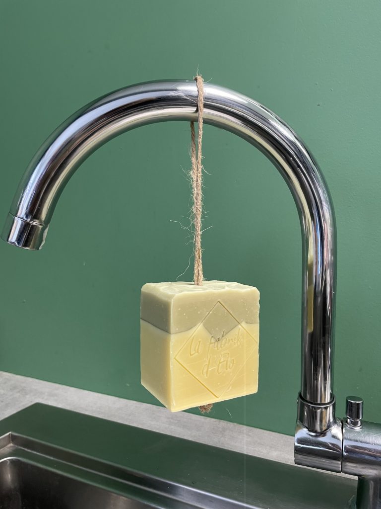 Photo d'un savon artisanal dynamisant, suspendu à un robinet